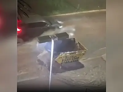 Enxurrada arrasta caçamba na Avenida Ricardo Brandão durante forte temporal em Campo Grande